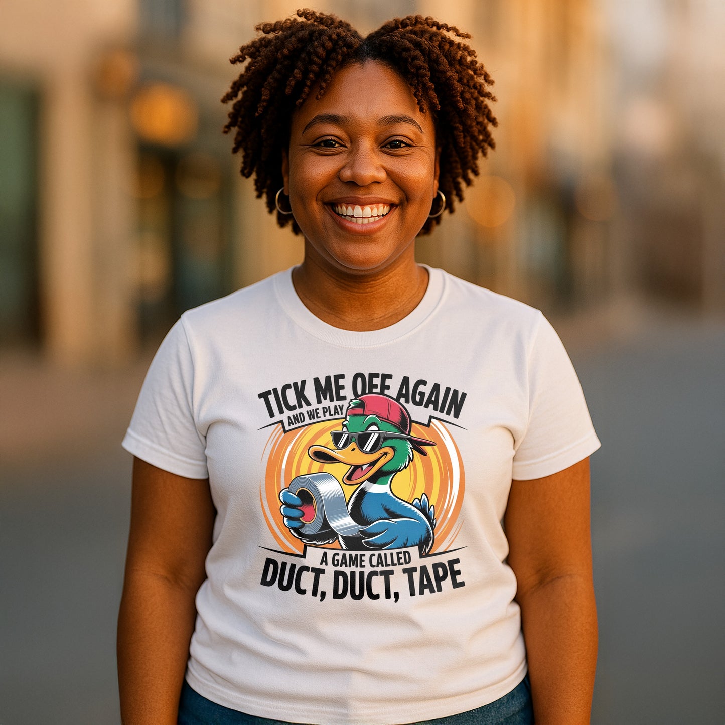 Cheerful African American woman wearing a white funny t-shirt featuring a cool cartoon duck with duct tape. The shirt says “Tick Me Off Again and We Play a Game Called Duct, Duct, Tape.” Ideal for casual wear, quirky personalities, and humorous gift ideas.