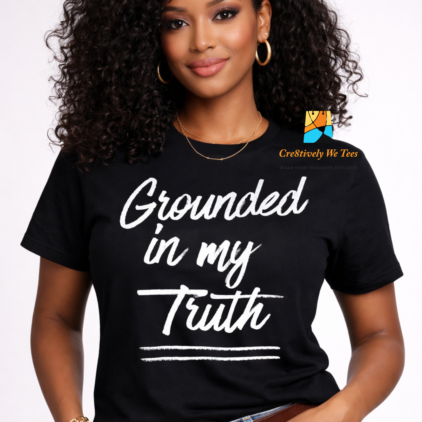 Woman wearing a black t-shirt with 'Grounded in my Truth' text, brand logo visible
