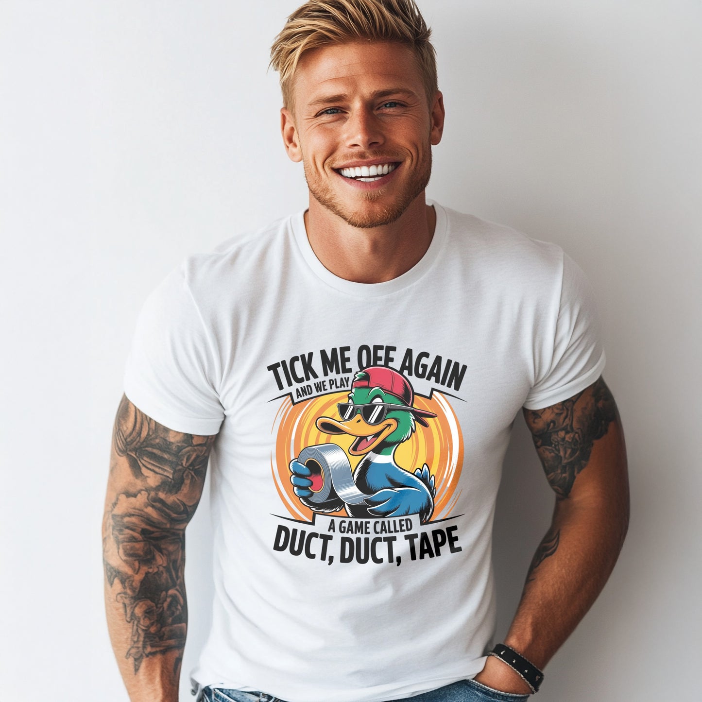 Smiling muscular man wearing a white graphic t-shirt with a funny cartoon duck holding duct tape. Text reads “Tick Me Off Again and We Play a Game Called Duct, Duct, Tape.” Perfect for sarcastic humor lovers and gag gift shoppers.