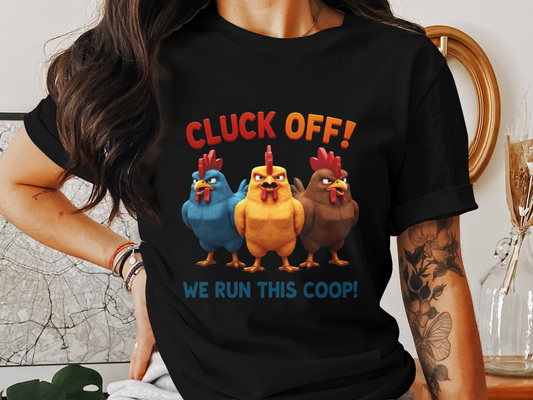 Black t-shirt with three animated hens in blue, yellow, and brown under the phrase “Cluck Off! We Run This Coop!”