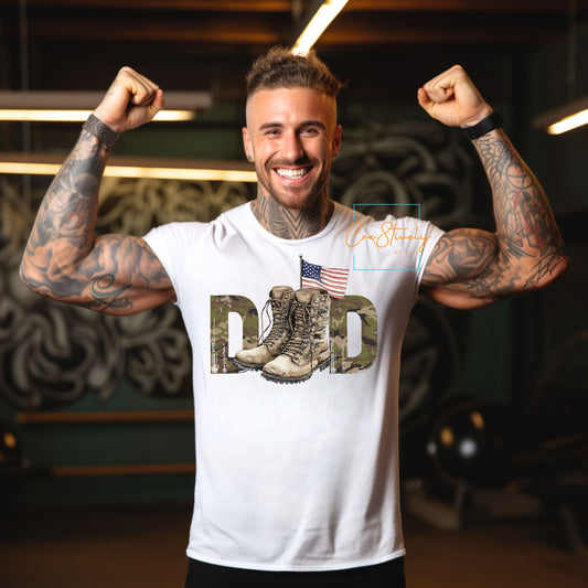 Man wearing white camo “Dad” t-shirt flexing his arms in a gym, showing pride and strength