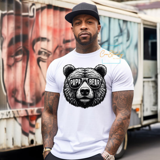 Man posing in a white t-shirt with a Papa Bear graphic and urban background.